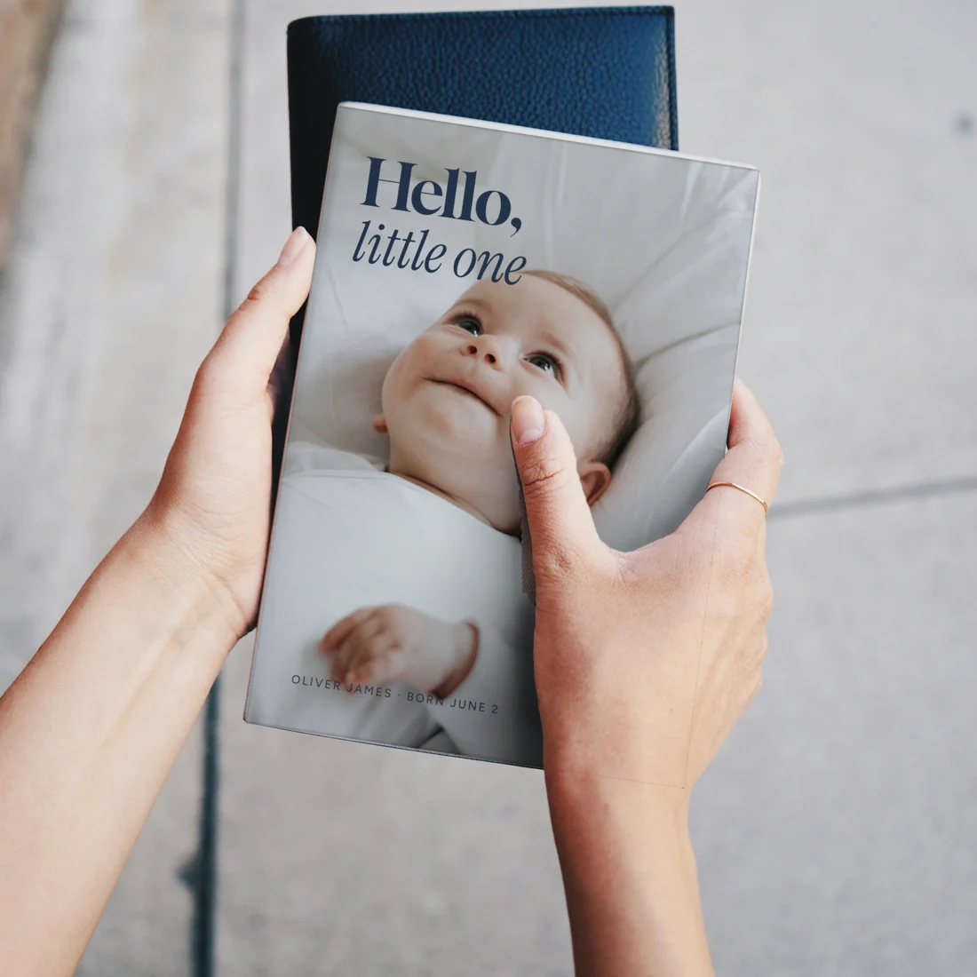 Hands holding a Hello, Little One book