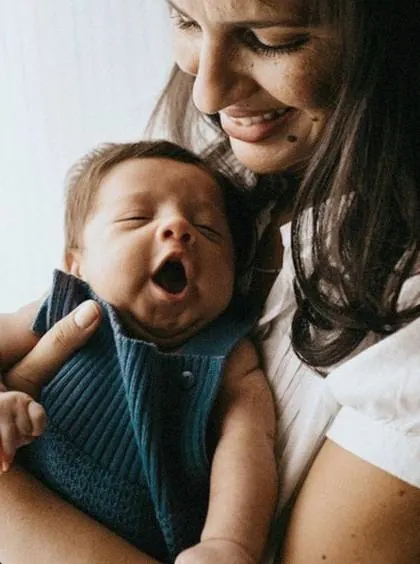 Mom holding her yawning newborn