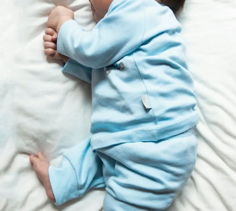 Newborn asleep on a white sheet